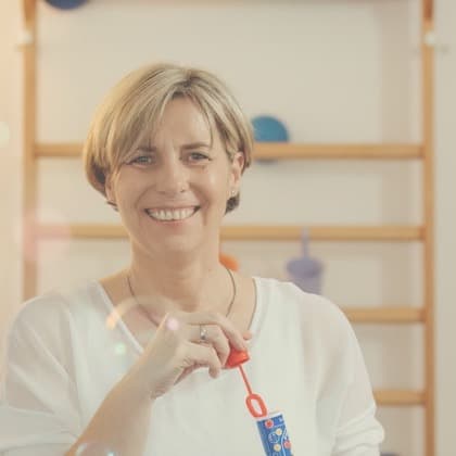Rita Schumann lacht und pustet Seifenblasen im Kursraum