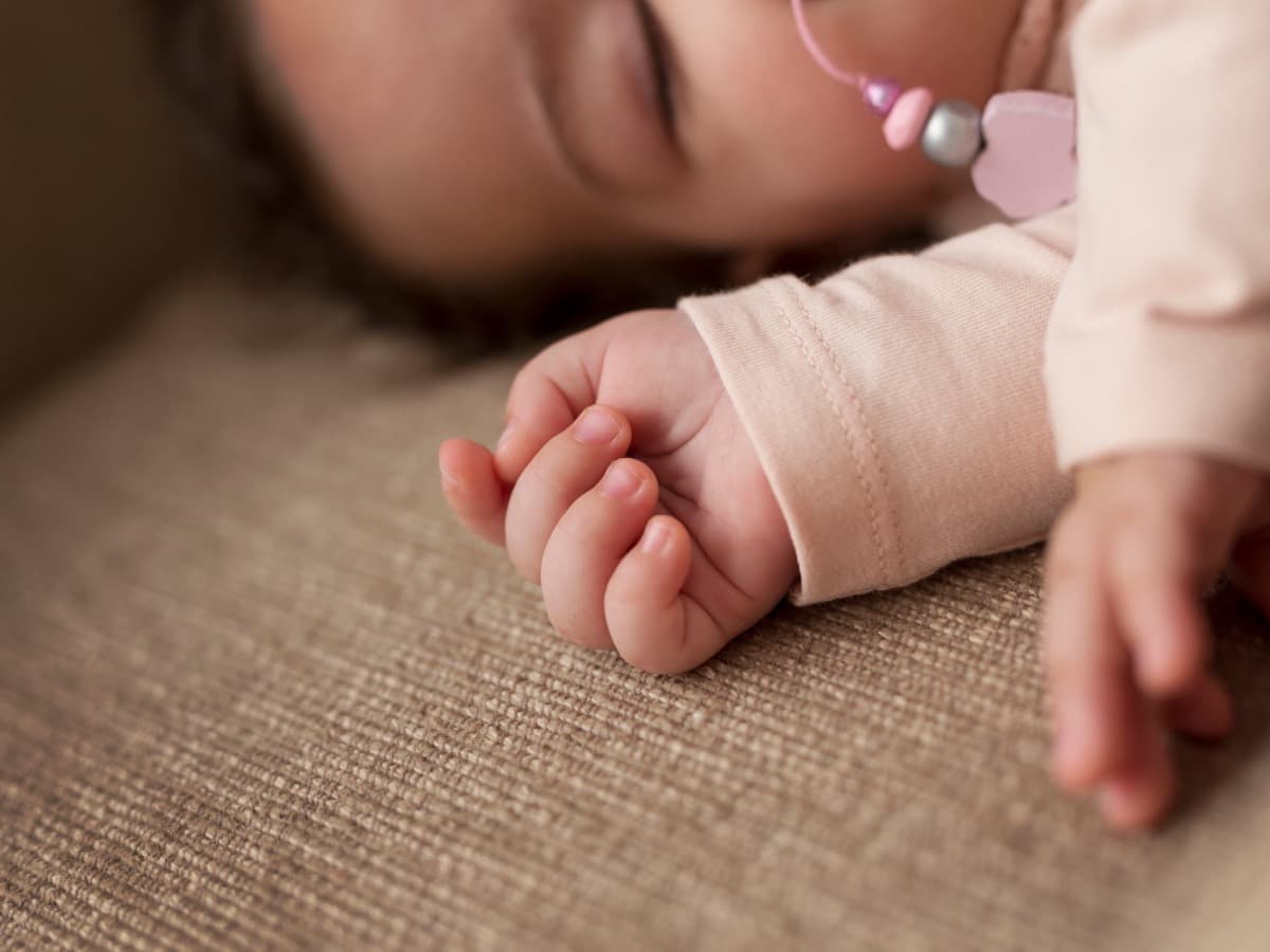 Ein schlafendes Baby liegt auf einer weichen Decke