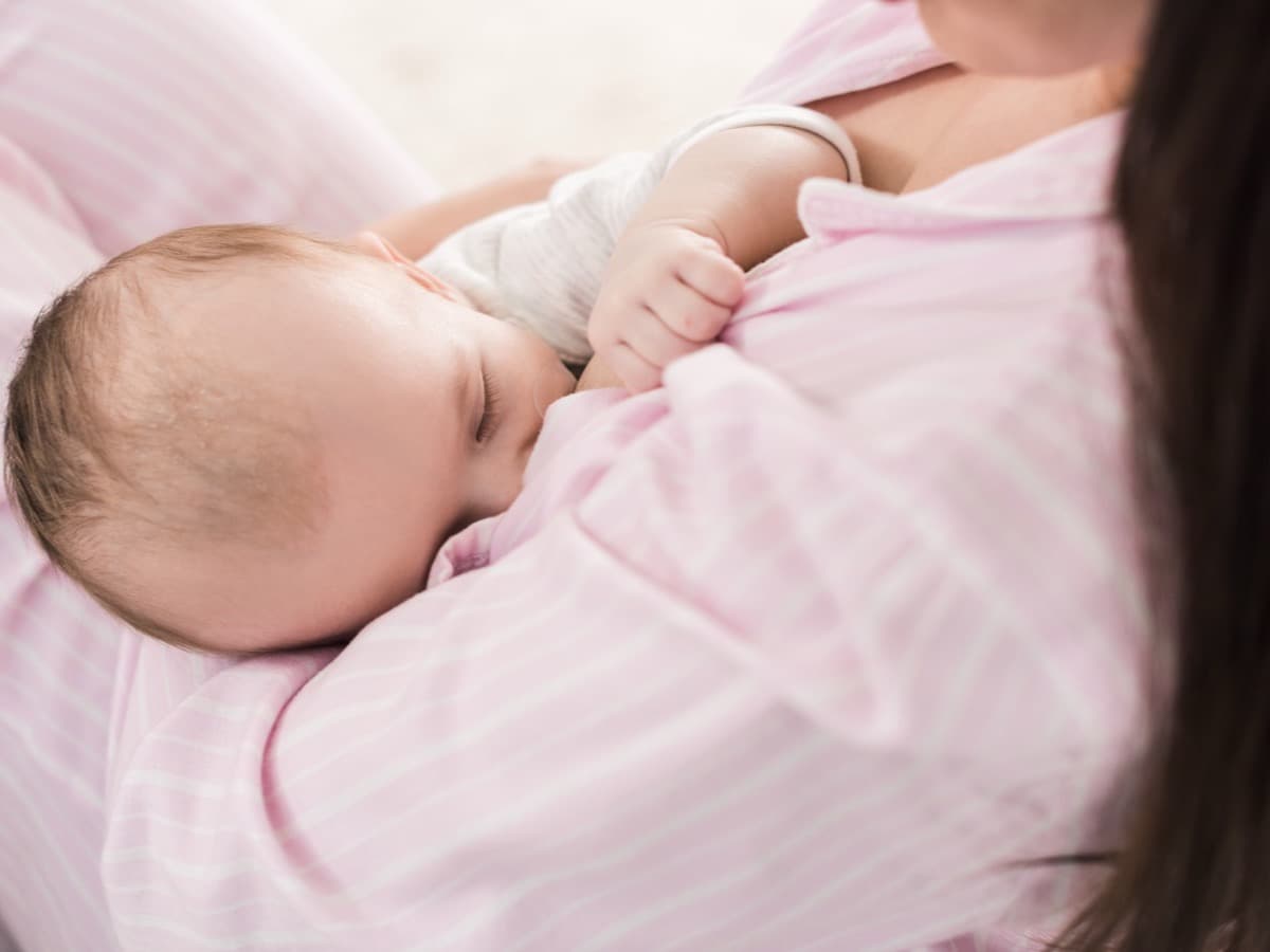 Ein Baby schläft an der Brust einer erwachsenen Person