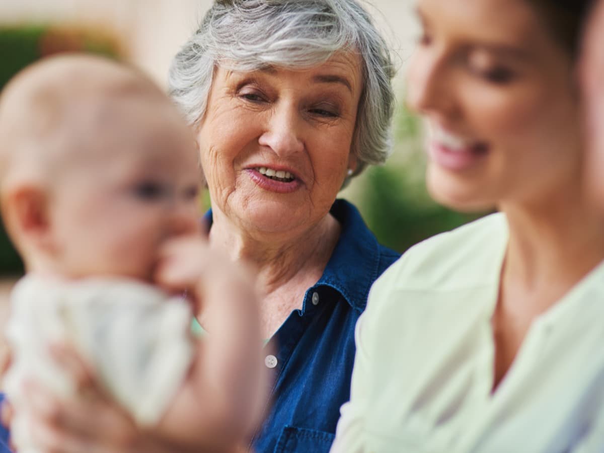 Großmutter und Mutter schauen gemeinsam auf ein Baby